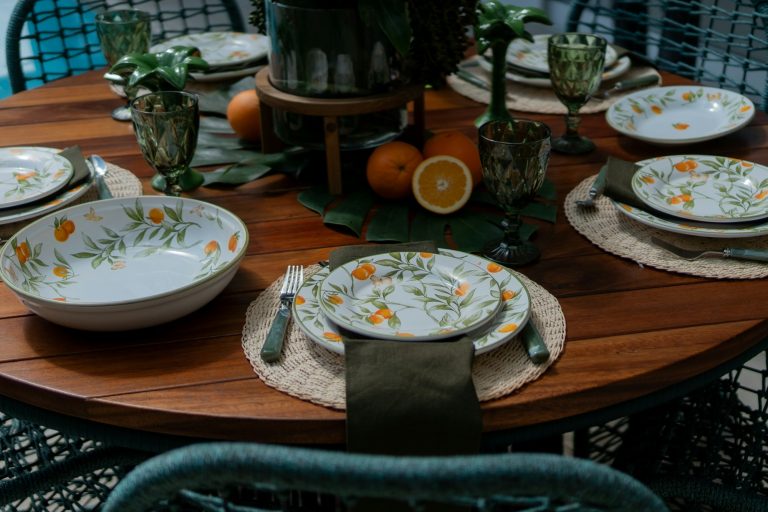 A wooden table is topped with an assortment of plates and bowls in a simple, lived-in arrangement.