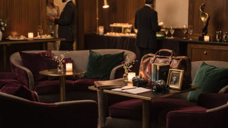 A retirement cocktail party arranged with lounge seating, standing conversation areas, food and drinks, and personal details that extend beyond the guest of honor’s career.